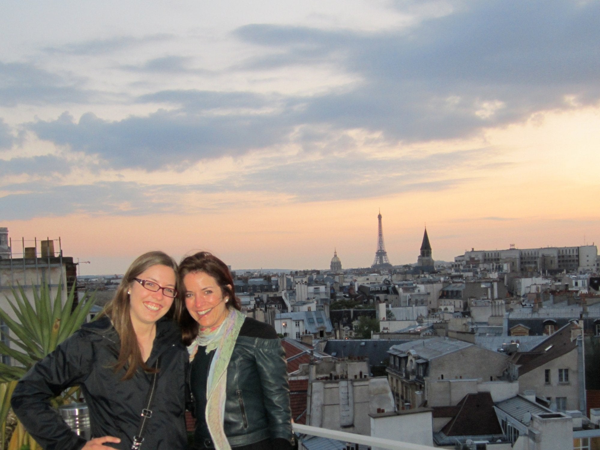 Two smiling women with background overlooking Paris and Eiffel Tower