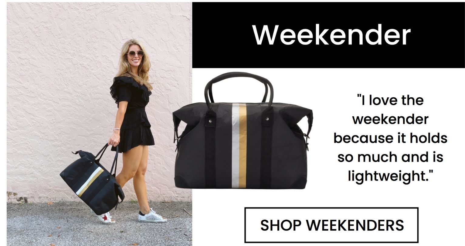 Woman in black romper carrying a black weekender bag