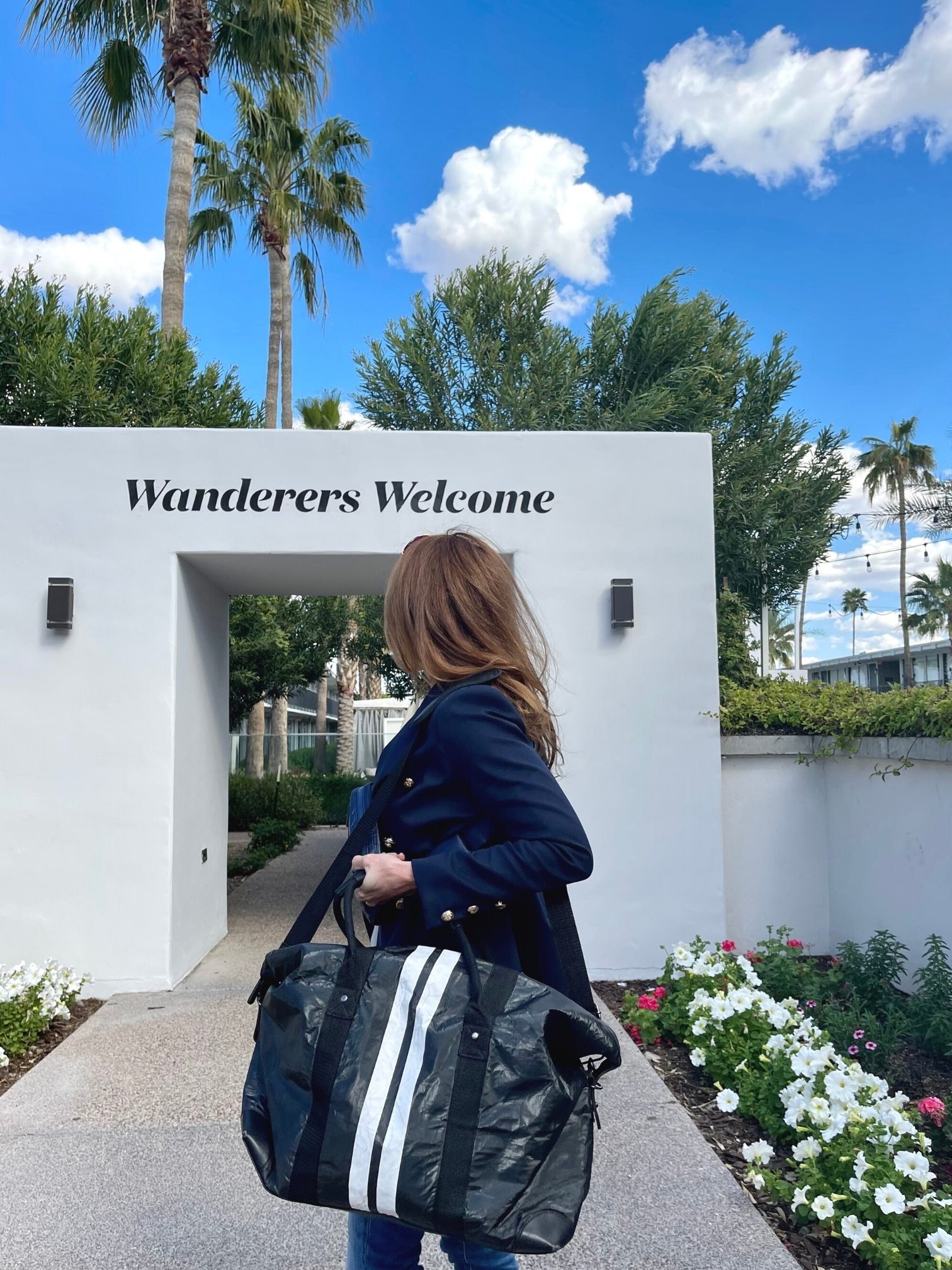 Woman in Arizona holding a shimmer black weekender bag across shoulder 