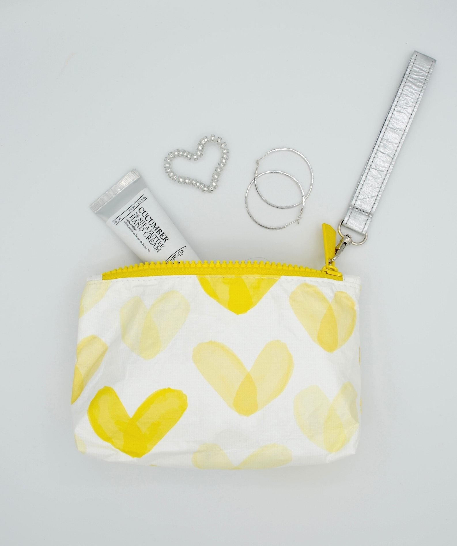 Yellow heart pattern zip wristlet containing lip gloss and earrings