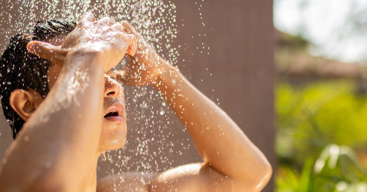 man washing hair in summer