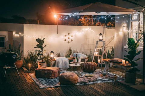 Cushion sits on the ground with solar lamps on the umbrella