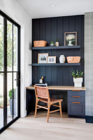 Deep dark blue paneling on wall of home office with wood chair, wood flooring, glass sliding doors and shelving. Interior design blog written by Vintage-etc about how wood paneling is the next big trend for living rooms, bedrooms, ceilings, entrance hallways and many more. Get this look with Vintage-etc. We make custom made & bespoke tables, benches, free-standing kitchen islands, desks, media units & wardrobes in our Cape Town & Johannesburg workshops - using Oak, Oregon, Ash, Beech, Birch Ply & Meranti. We also sell imported furniture, provide design consulting services & make soft furnishing e.g. sofas & upholstered chairs in linen, velvet & stain resistant fabric 