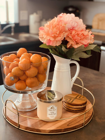 Display in kitchen on Wooden counter top of a tray with a scented candle, orange flowers in a white vase and oranges/clementine’s in a glass fruit bowl. Interior design blog about our tips on bringing your kitchen to life without spending too much money. Written by vintage-etc in Cape Town. We make custom made & bespoke tables, benches, free-standing kitchen islands, desks, media units & wardrobes in our Cape Town & Johannesburg workshops – using Oak, Oregon, Ash, Beech, Birch Ply & Meranti. We also sell imported furniture, provide design consulting services & make soft furnishings e.g. sofas & upholstered chairs in linen, velvet & stain resistant fabric.