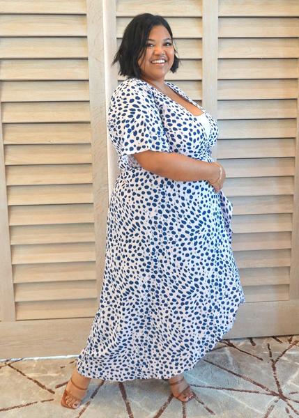 A curvy woman wearing a maxi wrap dress tied for a slimmer look