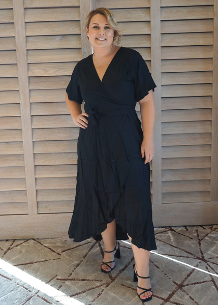 a curvy woman wearing the maxi wrap dress midnight black
