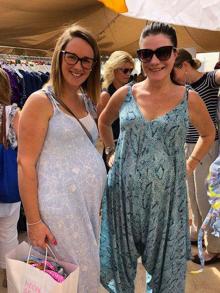 Two pregnant women wearing maternity jumpsuits from Neonstar at an outdoor market in dubai