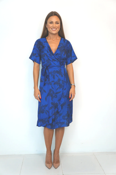 A model posing in The Flirty Wrap Dress Midi - Royal Garden for work