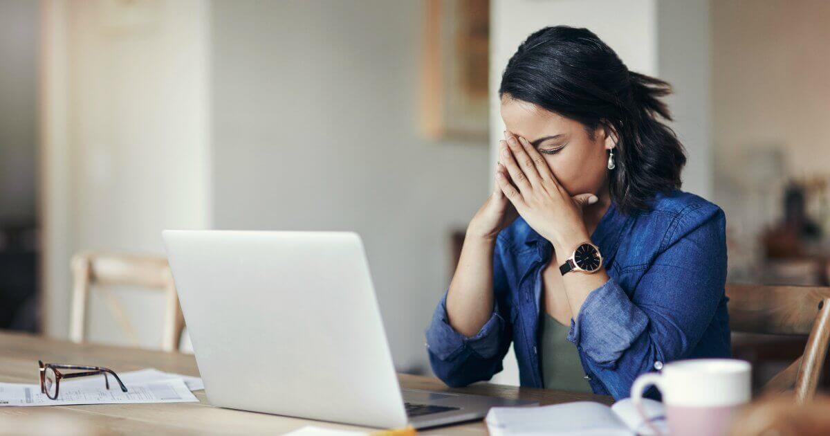 woman at a computer looking stressed 