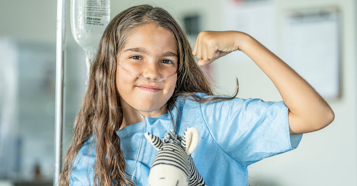 A young girl in the hospital, flexing her muscles