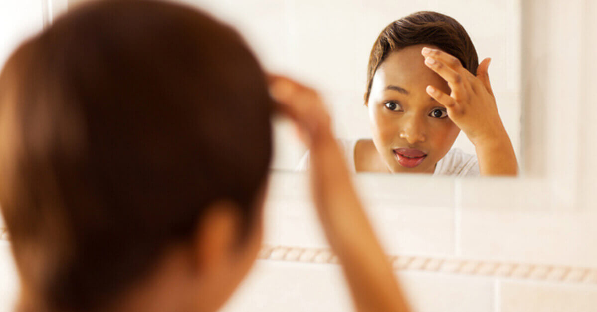 Woman checking her complexion in the mirror