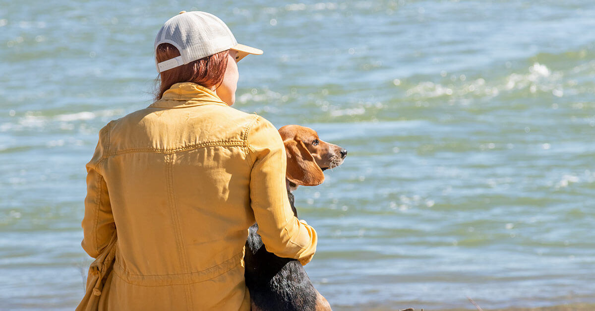 Woman with puppy by the water