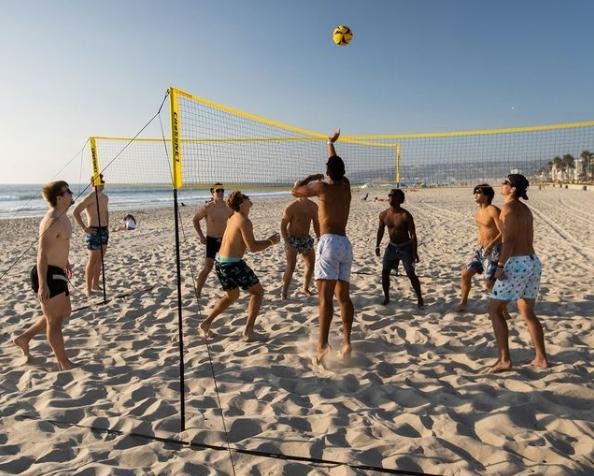men on beach playing crossnet