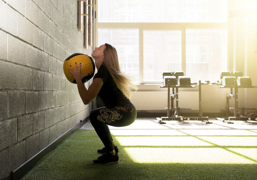 woman doing an exercise with a heavy medicine ball