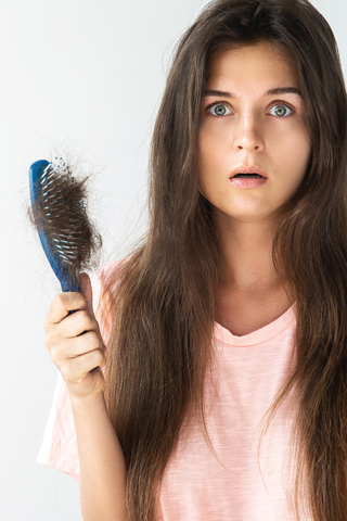 a woman experiencing hair loss