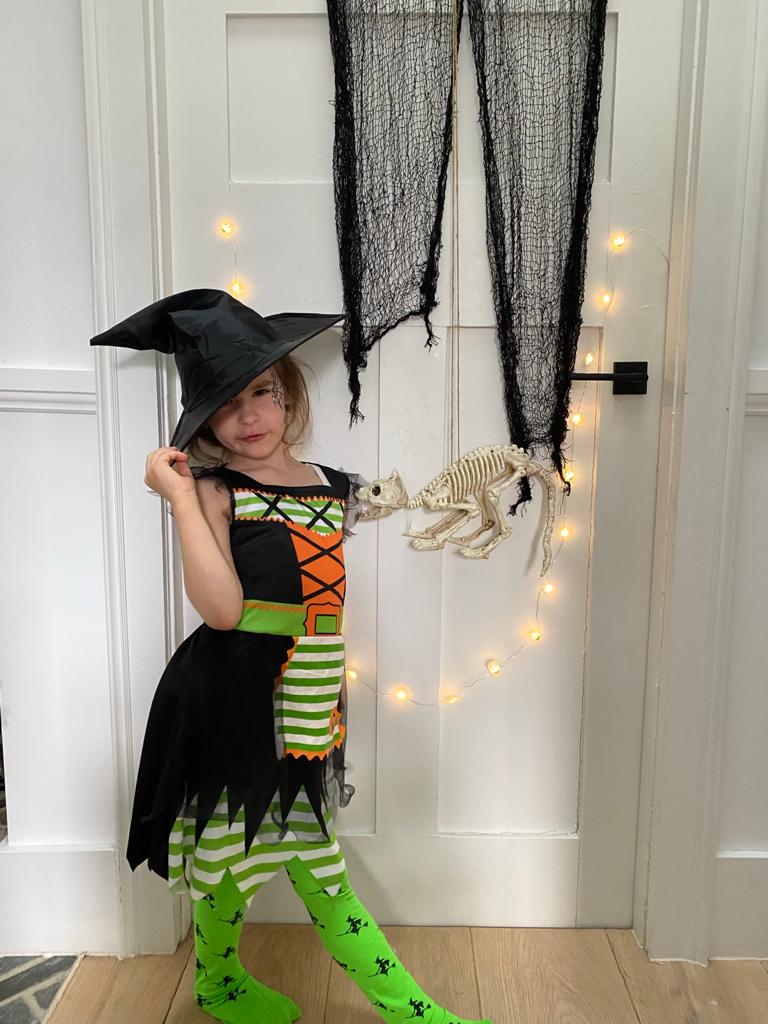 Little girl dressed up as witch at home for Halloween