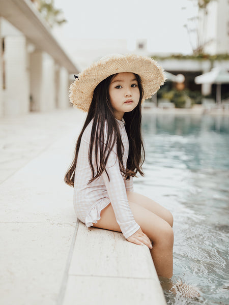Little girl at Calile Hotel pool wearing Willow Swim Sophia in peachy gingham