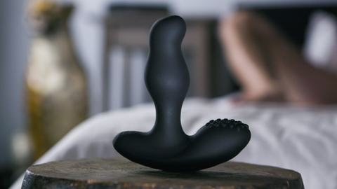 Thor rotating prostate massager sitting on a nightstand.
