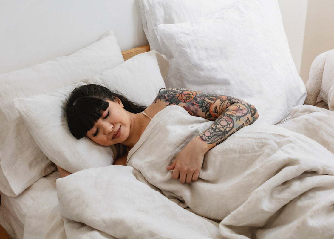 Woman sleeping in linen bedding