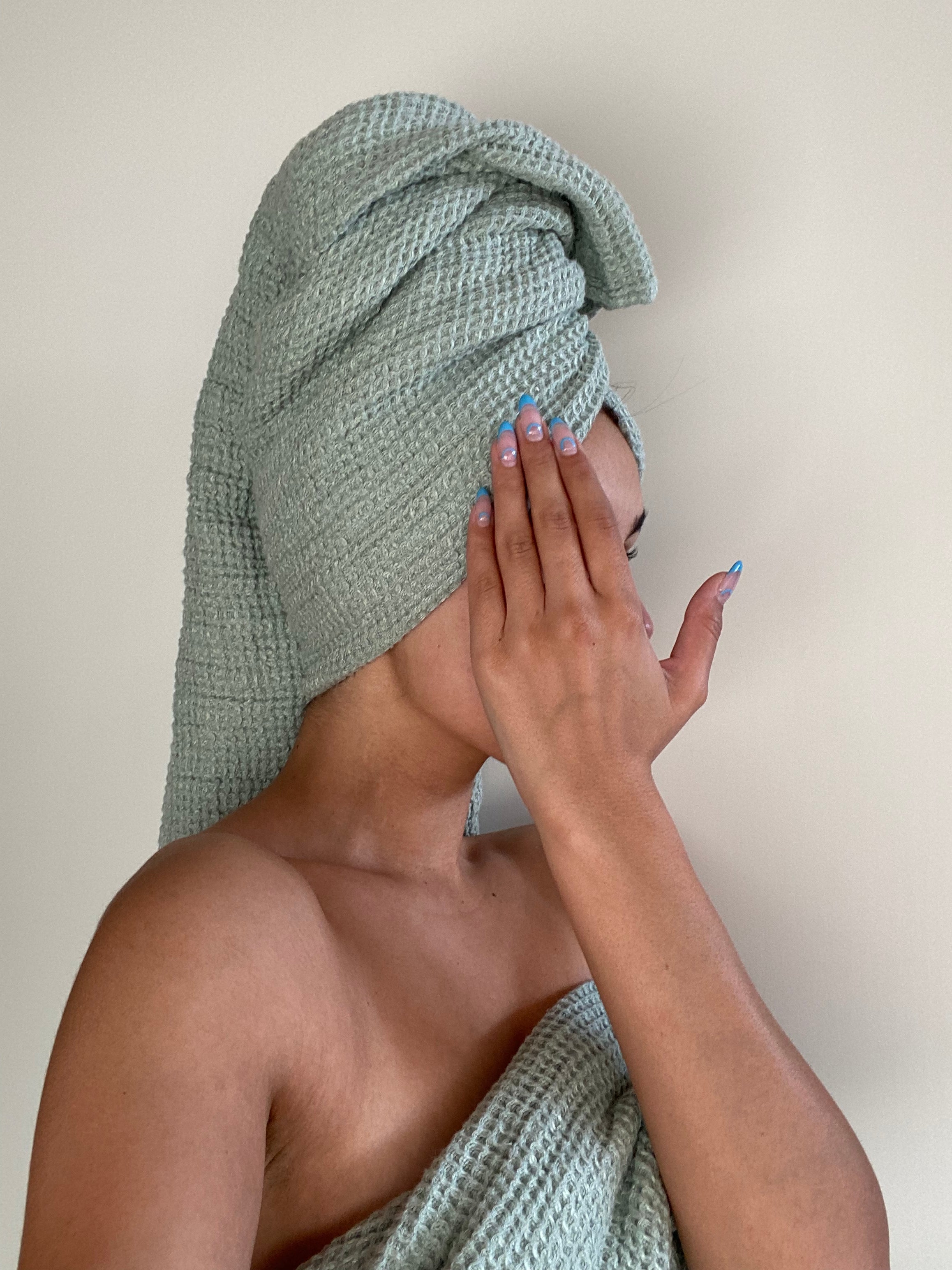 Girl wearing Flax Home waffle linen Bath Sheets in the colour Mint.