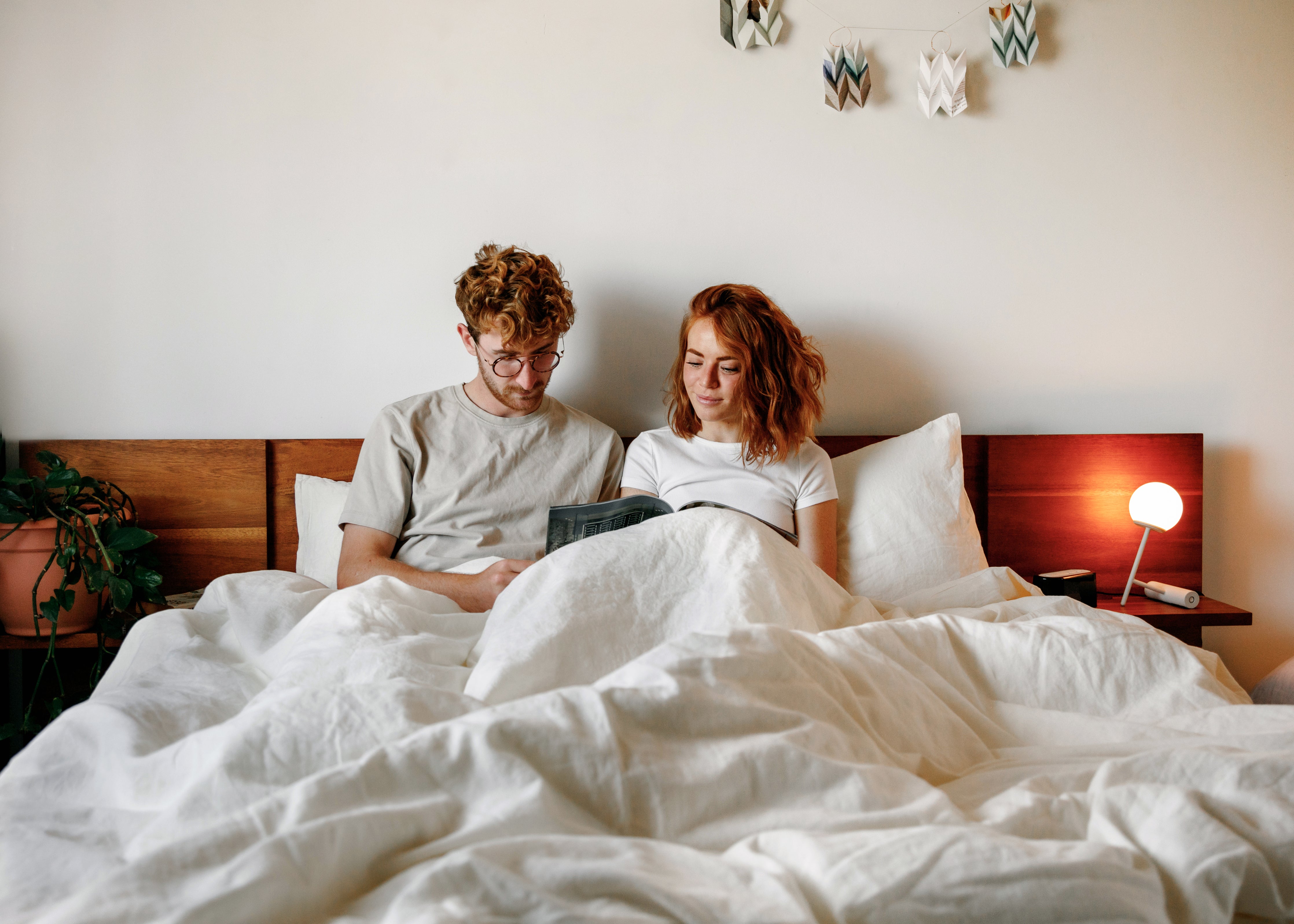 Couple reading in bed under Wilet linen cotton bedding