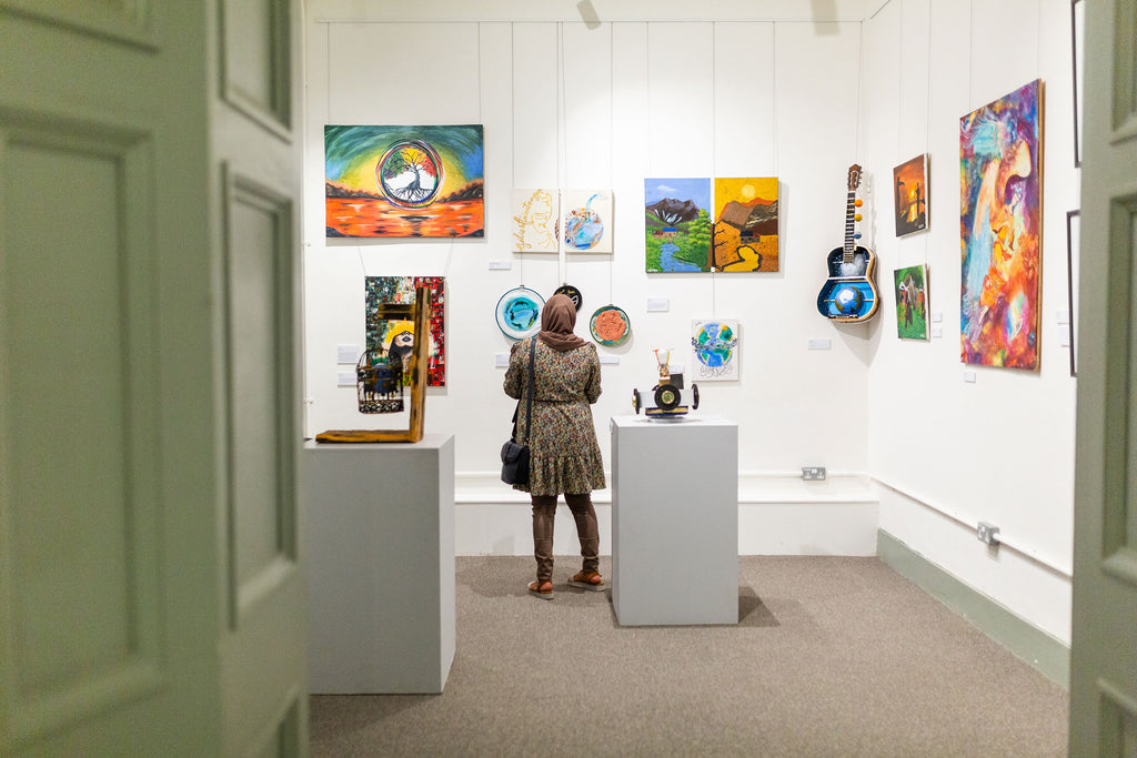 A woman in the exhibition space looking at the art pieces
