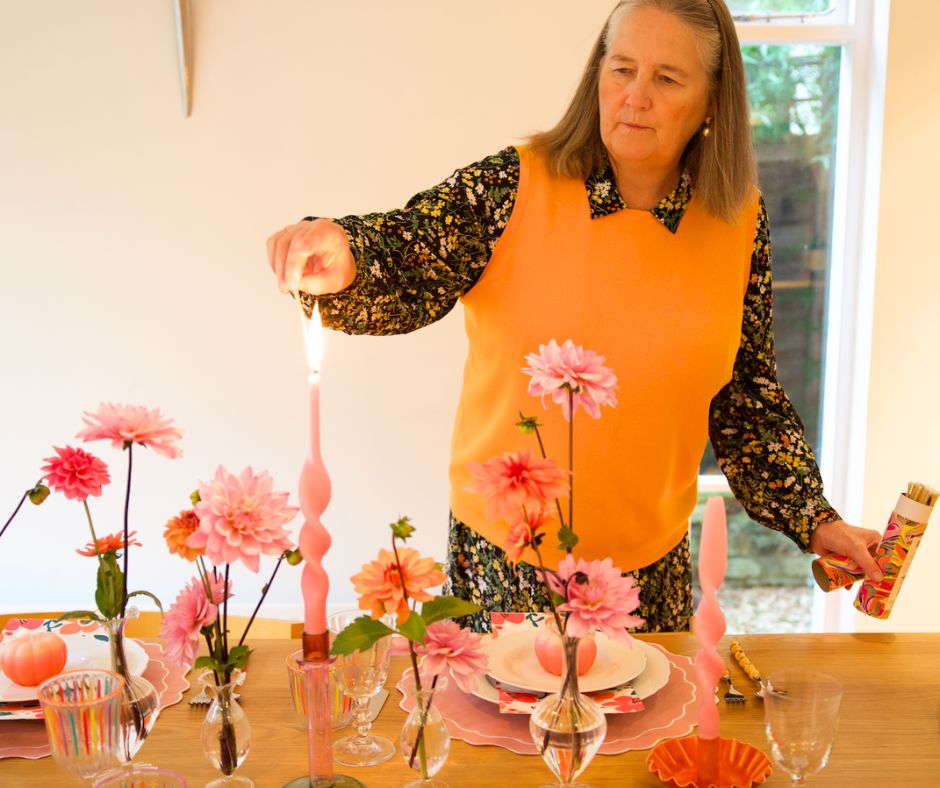 Clare Harris lighting a candle at a dinner table