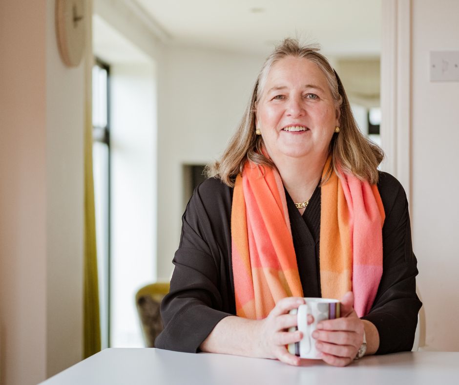 Clare Harris, founder of Talking Tables sat at a table with a mug