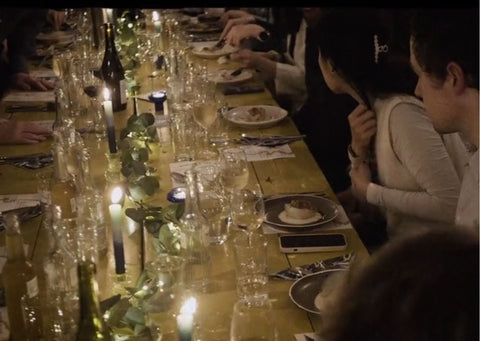 Dining table dressed with Talking Tables product and people sat round