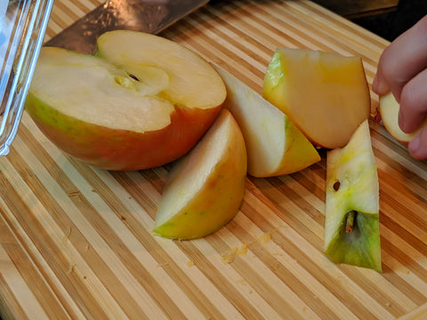 Apples being sliced on a cutting board