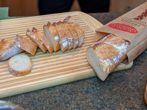 Baguette slices on a two-tone bamboo cutting board