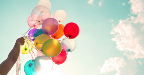 A woman holding balloons for a summer gathering.