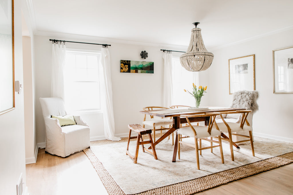 Mismatched dining chairs, vintage turkish persian rug layered over jute, and cloudlike linen curtains.