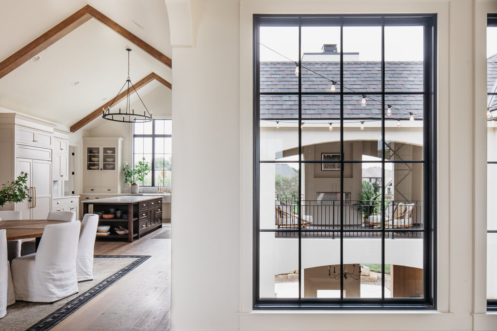 Love seeing the open courtyard, the living room, and dining room with Verellen, Loloi rugs, and gorgeous lighting!