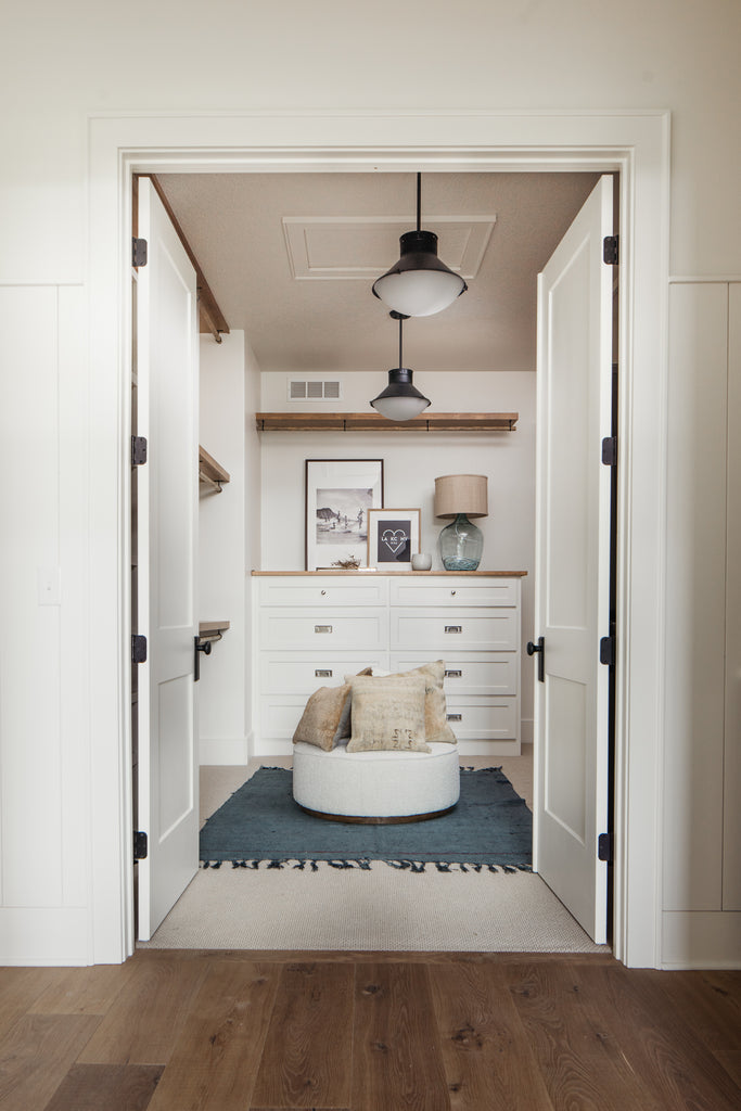 Master closet design with built in cabinetry and boutique style clothes rack.