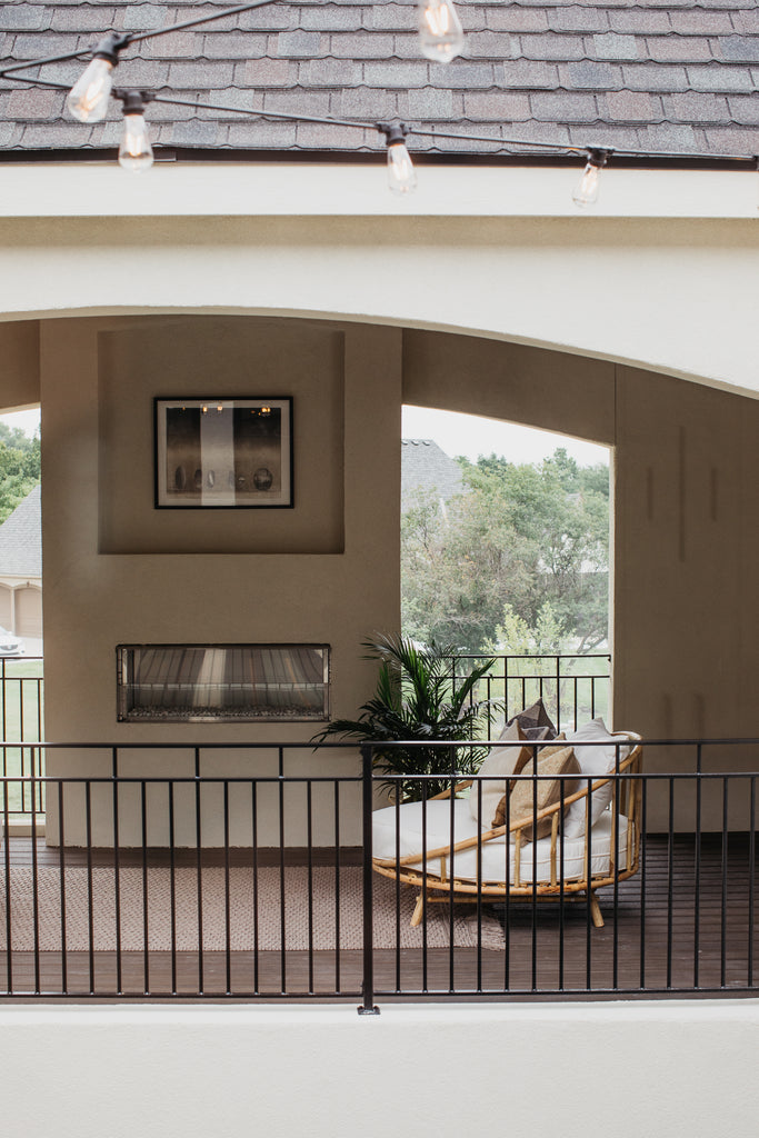 A cozy spot as viewed across the open courtyard to stop in during the Artisan Home Tour in Kansas City, Missouri with outdoor furniture, rug, and art!