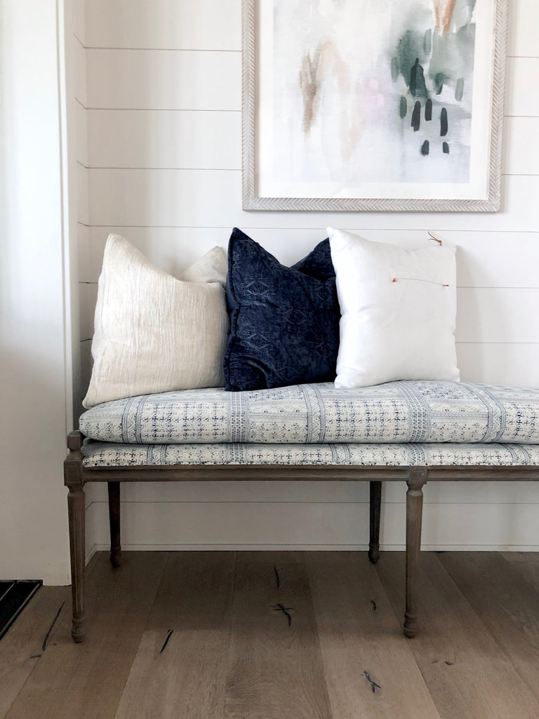 Dalia sectional slipcovered in grey linen by Cisco Brothers in this midwest modern farmhouse near Ames, IA.  Kai wool rug by Jaipur in beautiful grey medallion pattern paired with a cognac leather Emmett sling chair by Four Hands.  All white kitchen with warm white oak wood floors by Joelle Elaine Design.