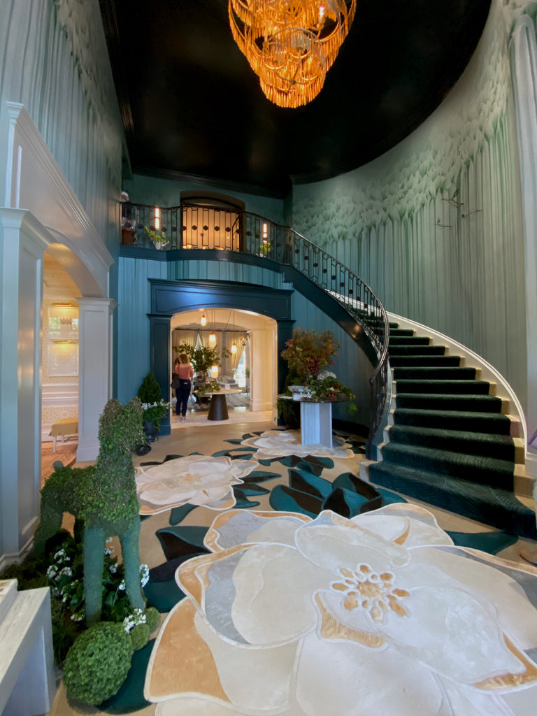 The Foyer by Rottet Studio  The 20' ceilings, romantic curved staircase and oversize hair-on-hide floral rugs were definitely a "welcome to Dallas" entrance!  Adored the brass chandelier and water feature (not pictured).