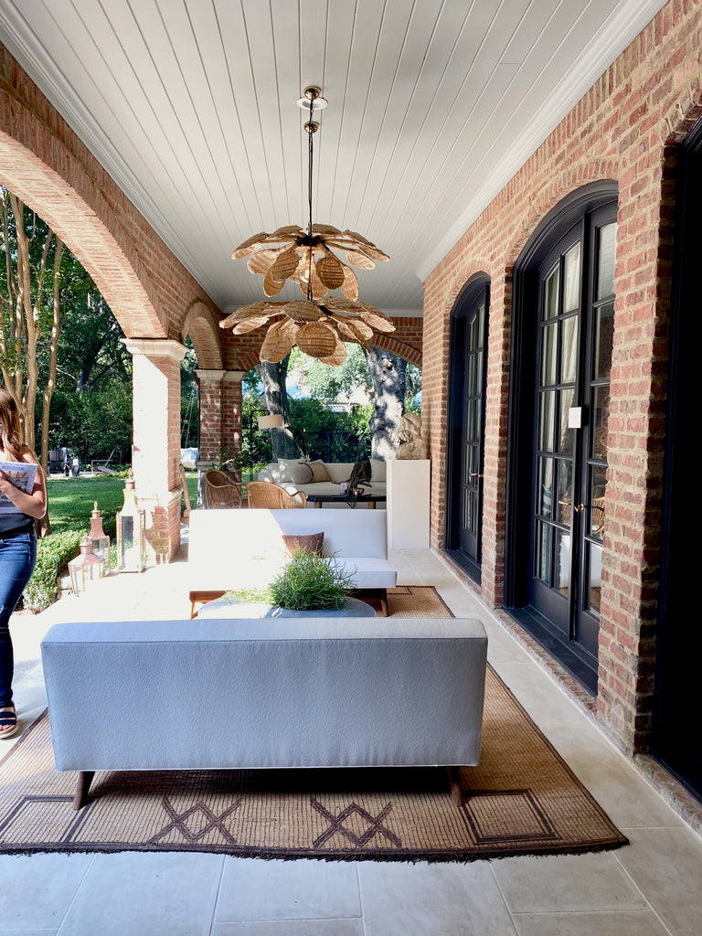 Covered Veranda by Kevin Spearman Design Group   When it's good, it's good.  White outdoor seating with natural mat rugs, woven lighting, gorgeous black trimmed windows with exposed brick...forget Dallas -- this felt like a five star resort!