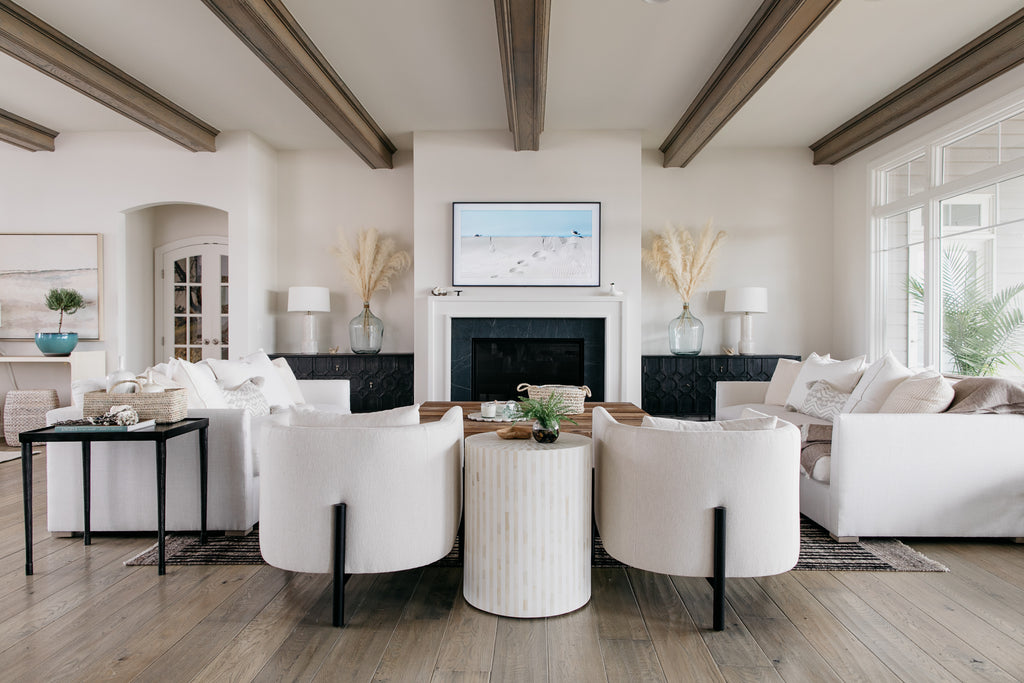 The Verellen Sullivan chairs and Thibaut sofas are a star of the show in crisp white linen in this modern coastal lakehouse in Omaha, Nebraska designed by Amethyst Home.
