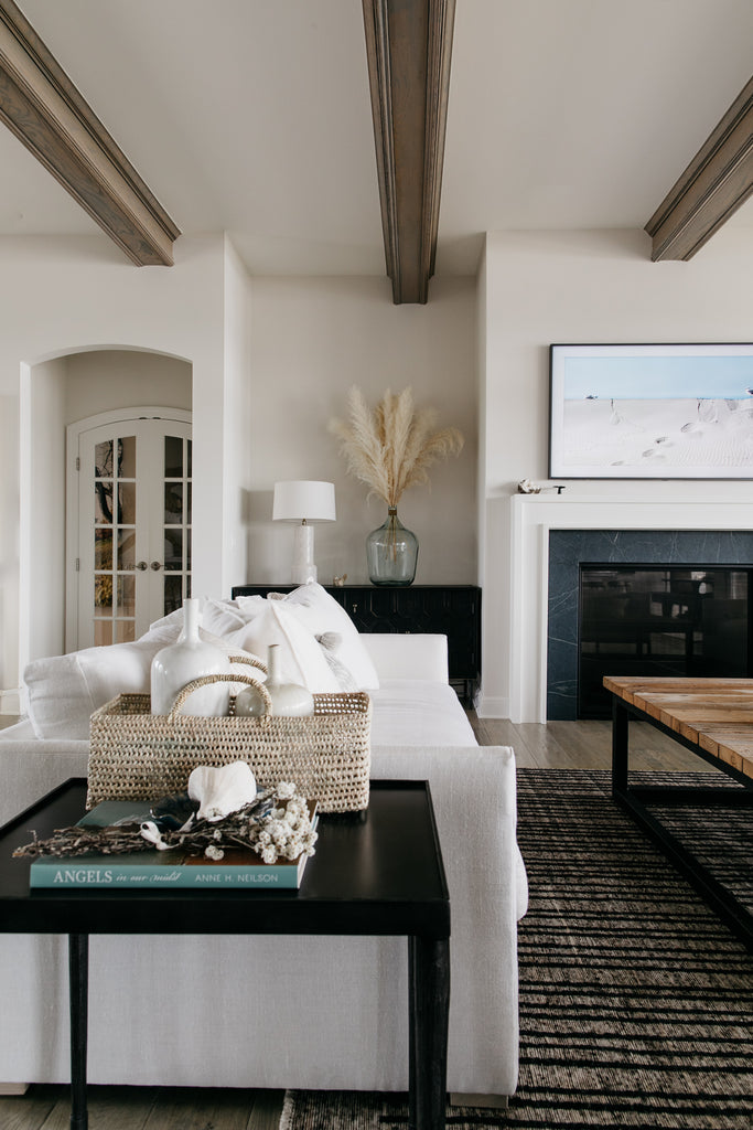 The black Lancaster side table is big enough for a deep 40" Verellen Thibaut sofa and works beautifully with this contemporary Moroccan rug, and rustic oversized coffee table. The side table generously holds the palm leaf baskets and coffee table book-sized Angels in our Midst, by Anne Neilson.