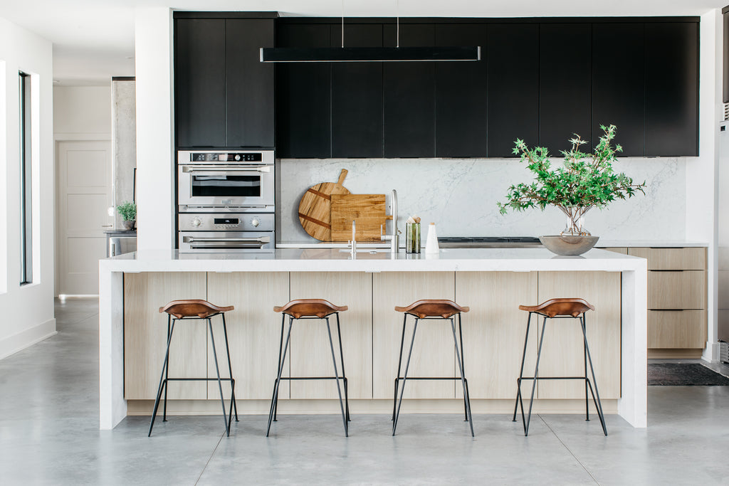 A bright and airy kitchen with sleek white quartz counters, steel appliances and bold black cabinetry.