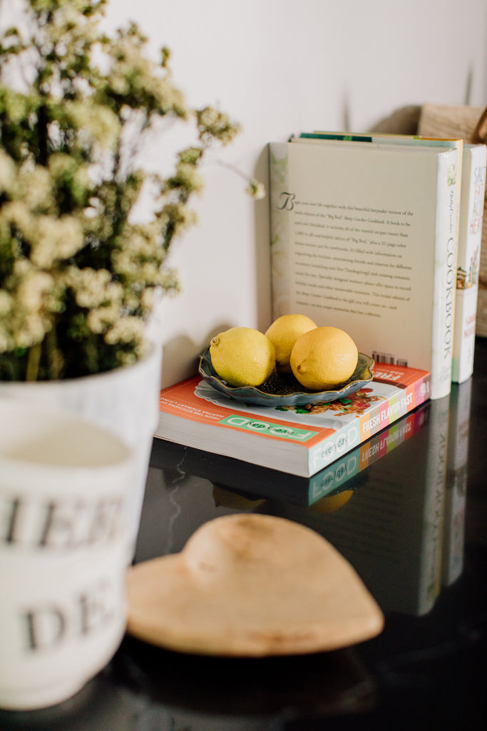 The pops of color with the cookbooks and lemons on top of the black quartz countertop with dramatic white veining is so much fun.