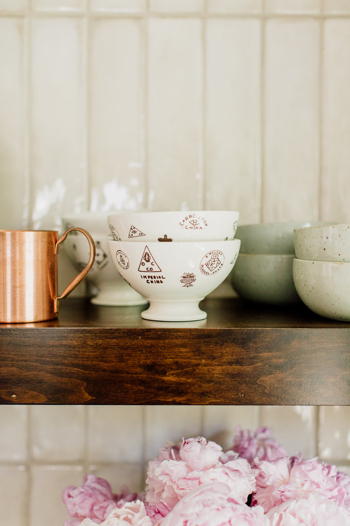 The custom-built open shelving in the kitchen is such a fun contrast to the cabinets. This is such a gorgeous way to show off cute ceramic and glassware along with seasonal decor and flowers.