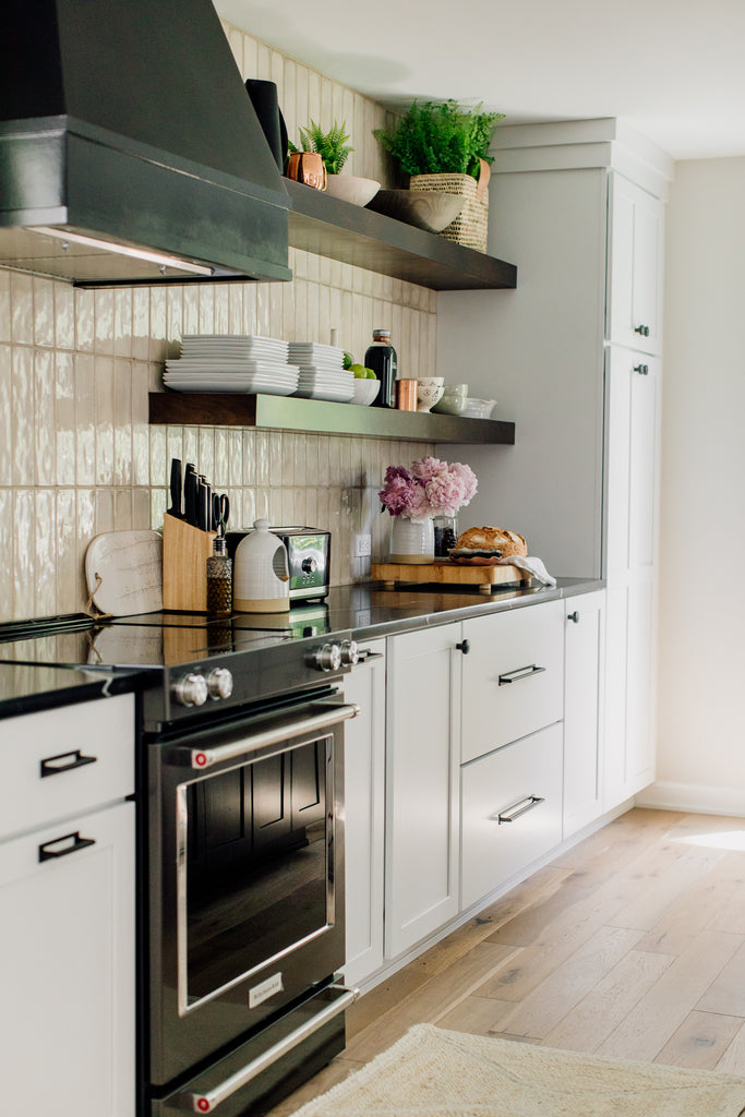 A Warm, Modern Kitchen: Before & After. A head-to-toe kitchen makeover transformed a typical modern family problem (cue outdated, tiny kitchen) into a bright, spacious kitchen of our dreams. The transformation included demo-ing walls and implementing a ceiling facelift, new floors, new cabinets, quartz, appliances, lighting, furniture, and rugs.