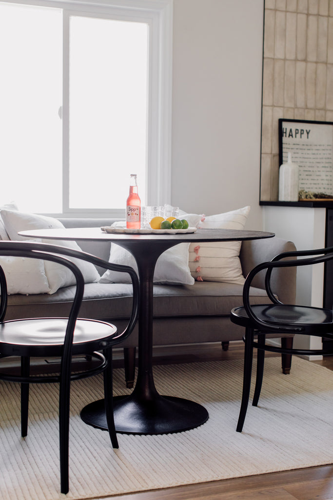 The tulip-shaped Sloane Dining Table is perfect for everyone to gather and enjoy time together paired with the Cisco Brothers Cove Sofa. The soft Hadley rug from Loloi brings so much warmth and texture to the floor to make this one of the coziest spots in the kitchen.