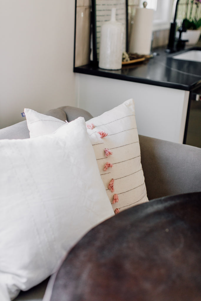 A sofa in the kitchen is such a fun idea along with adding soft pops of color with the pillows on this Cisco Brothers Cove Sofa.