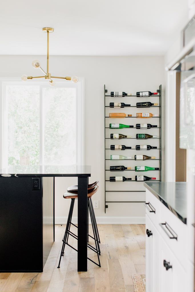 The fabulous Equestrian counter stool's leather seat visually floats against the black island in a blend of utilitarian and rustic design. The Wine Rack was such a fun addition to this space, it's one of our favorite spots in the kitchen.