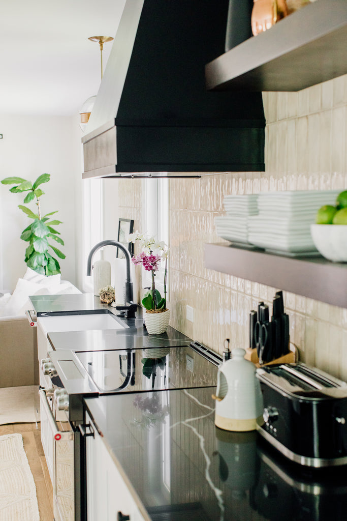 A Warm, Modern Kitchen: Before & After. A head-to-toe kitchen makeover transformed a typical modern family problem (cue outdated, tiny kitchen) into a bright, spacious kitchen of our dreams. The transformation included demo-ing walls and implementing a ceiling facelift, new floors, new cabinets, quartz, appliances, lighting, furniture, and rugs.