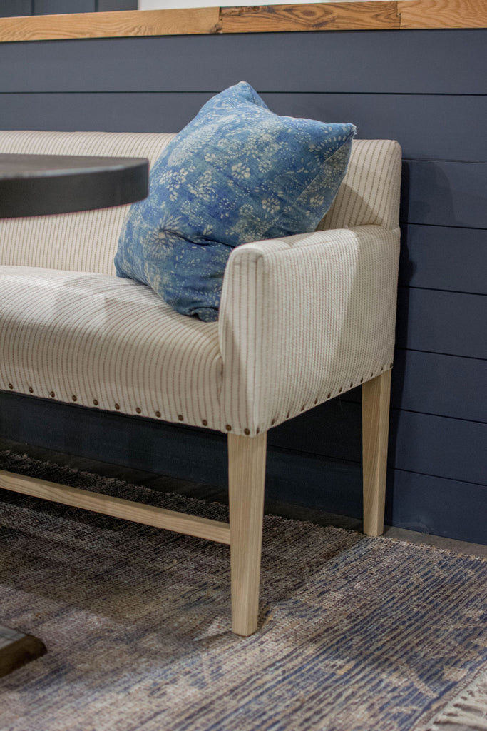 For basement dining, the client fell in love with a Verellen Thibaut dining bench paired with a handmade oval dining table and a Loloi Cornelia rug